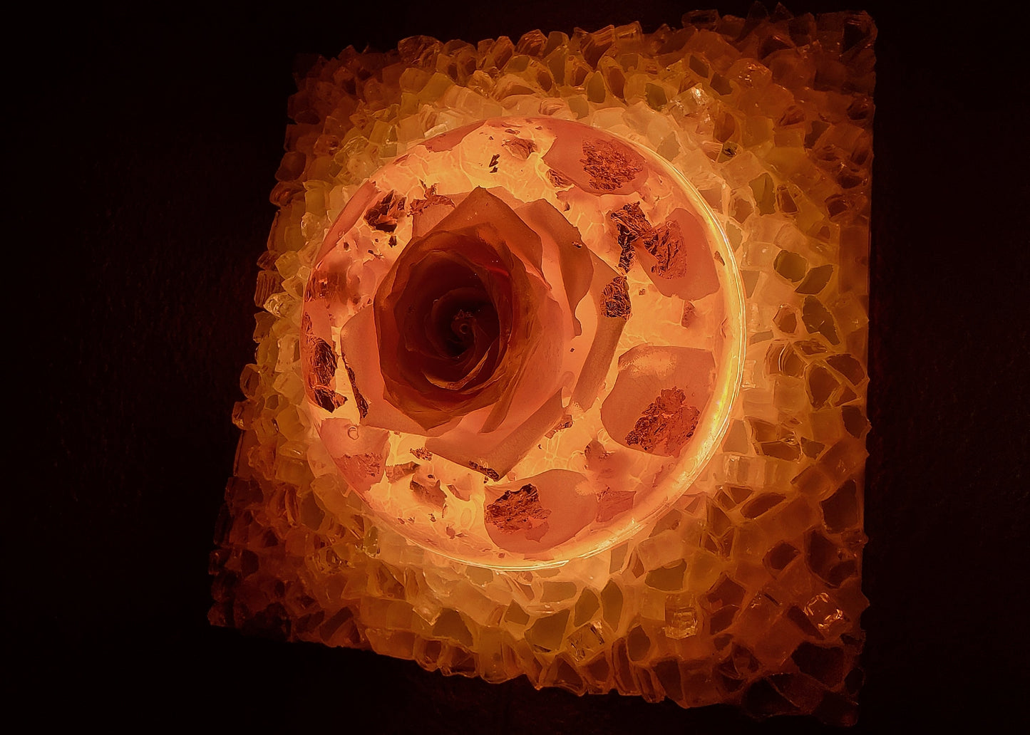 Square light fixture with a textured surface and warm glow on a dark background